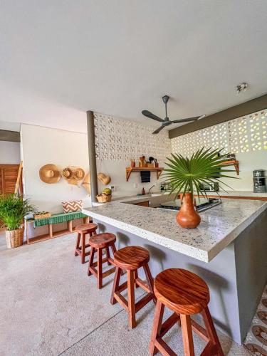 a kitchen with four stools and a counter in a room at Puerto Escondido Pool, Beach Club, Starlink WiFi & AC in Paso Hondo