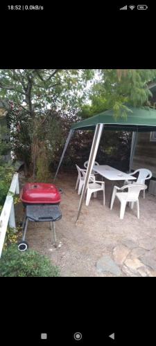 a picnic shelter with a table and chairs and a red seat at Cabaña en Guanaqueros in Guanaqueros