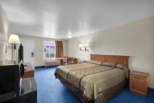 a hotel room with a bed and a television at Knights Inn Jacksonville at Dix Ellis Trail in Jacksonville