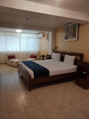 a bedroom with a large bed and a couch at Lucky Star Hotel in Chiclayo