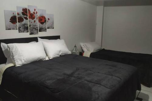 a bedroom with a bed with black sheets and white pillows at Liberdade! Apto no centro! in Caçador