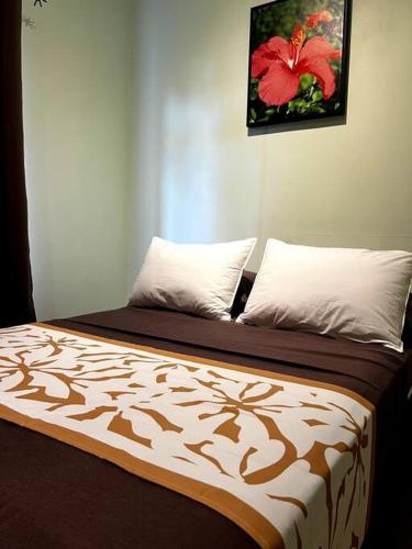 a bed with two pillows on top of it at Fare Apetahi - Maison 2 Chambres in Uturoa