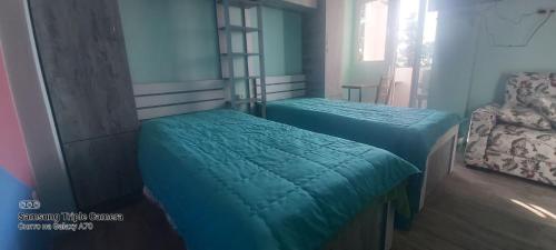 a bedroom with two beds and a chair at Квартира у моря Колхида in Makhinjauri