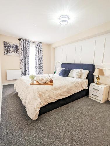 a bedroom with a large bed with a blue headboard at Entire 2 Bedroom and 2 Bathroom Apartment in Manchester City -Free underground Parking in Manchester