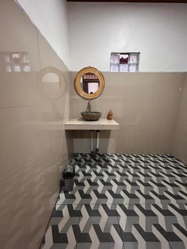 a room with a mirror and a black and white floor at Batur cottage in Kubupenlokan