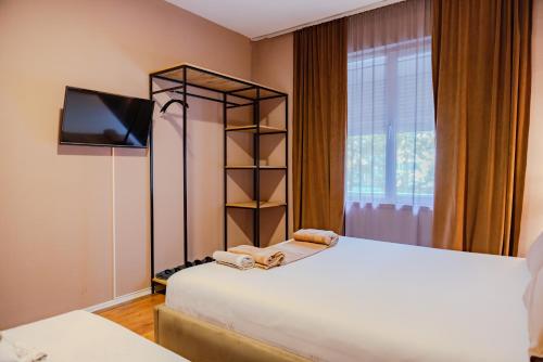 a bedroom with two beds and a tv and a window at BejartApartment2 in Tirana
