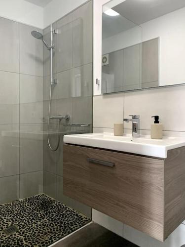 a bathroom with a sink and a shower with a mirror at Beach Front House 'Casa Neen' in Corralejo