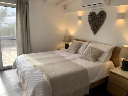 a bedroom with a bed with a heart on the wall at Beach Front House 'Casa Neen' in Corralejo