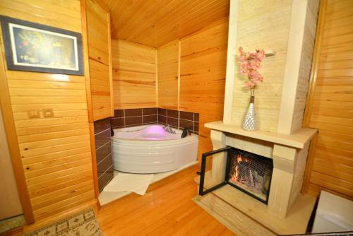 a bath tub in a room with a fireplace at Assortie La Villa Hotel in Ağva