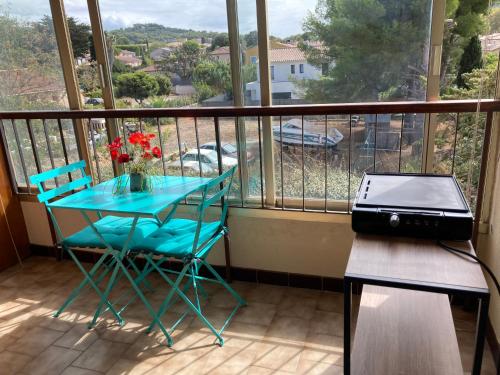 - un balcon avec une table, des chaises et un ordinateur portable dans l'établissement Studio a 5OOm des plages de Bonnegrace, à Six-Fours-les-Plages