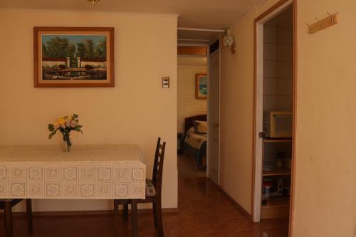 a room with a table with a vase of flowers on it at Cómoda casa para parejas in Coquimbo
