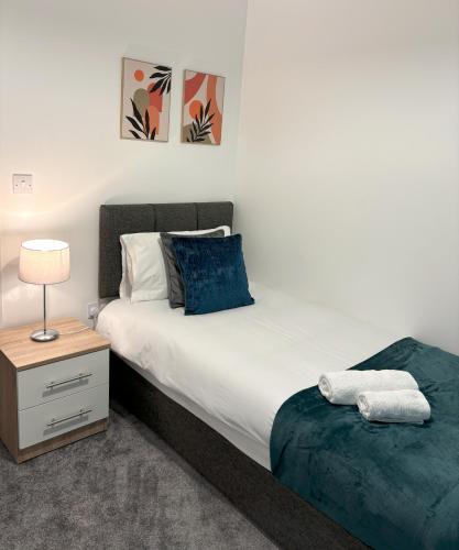 a bedroom with a bed and a table with a lamp at Delight Marvel-Waltham Place - Ashford in Ashford