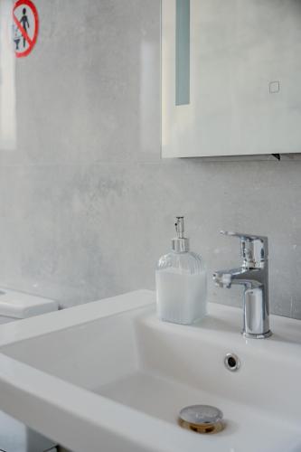 ティラナにあるBejart Apartment 4の石鹸ディスペンサーが付いたバスルームのシンク