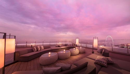 una terrazza panoramica con divani e candele sul balcone di Conrad Manila a Manila