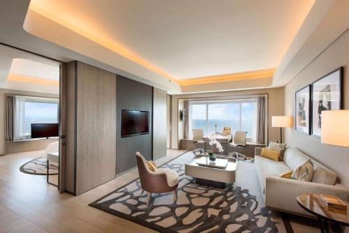 a large living room with a couch and a tv at Conrad Manila in Manila