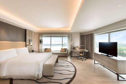 a bedroom with a large bed and a television at Conrad Manila in Manila