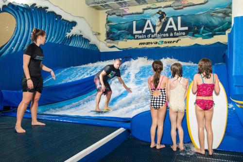 a group of people standing in front of a wave surfing exhibit at Holiday Inn Laval Montreal by IHG in Laval