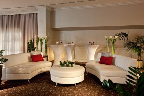 a living room with two white couches and a table at Holiday Inn Laval Montreal by IHG in Laval