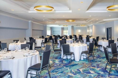 a banquet room with white tables and chairs at Holiday Inn Laval Montreal by IHG in Laval