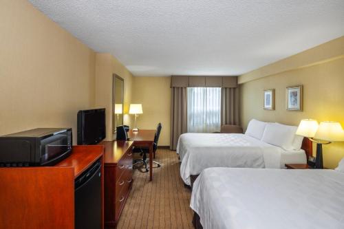 a hotel room with two beds and a television at Holiday Inn Laval Montreal by IHG in Laval