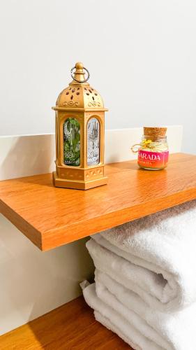 a clock sitting on top of a wooden shelf at Pousada Passarada - Tudo novinho te esperando in Pirenópolis