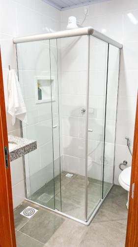 a glass shower in a bathroom with a toilet at Pousada Passarada - Tudo novinho te esperando in Pirenópolis