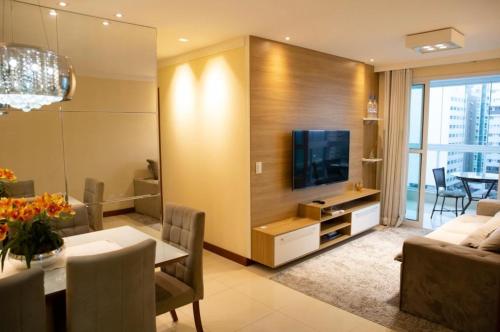 a living room with a dining table and a television at Apartamento Beira Mar em Praia de Itaparica - Vila Velha- ES in Itaparica
