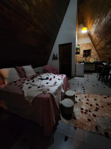 a bedroom with a large bed and a kitchen at Elshadaychale in Ibiúna