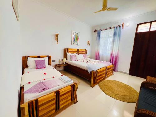 a bedroom with two beds and a window at Nungwi Beach Front in Nungwi