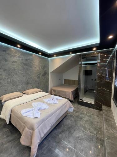 a bedroom with two beds and a glass wall at Suíte Silver com sofa cama in Santo Antônio do Descoberto