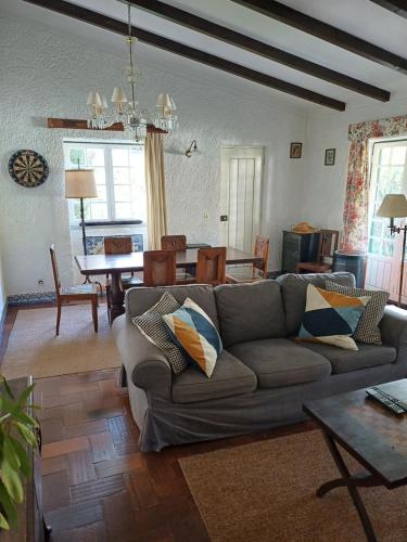a living room with a couch and a dining room at Casa dos Pinheiros in Casal do Narcizo
