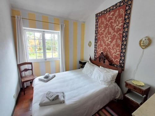 a bedroom with a bed with two towels on it at Casa dos Pinheiros in Casal do Narcizo