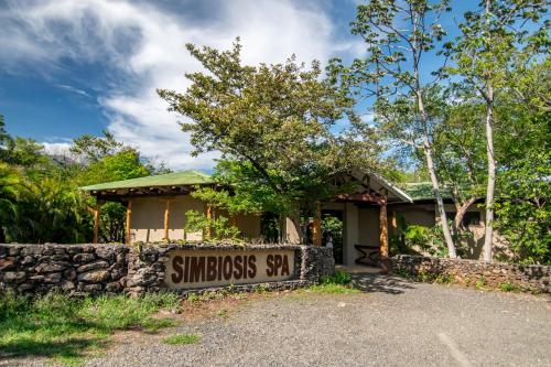 a sign in front of a small building with a house at Hacienda Guachipelin Volcano Ranch Hotel & Hot Springs in Liberia
