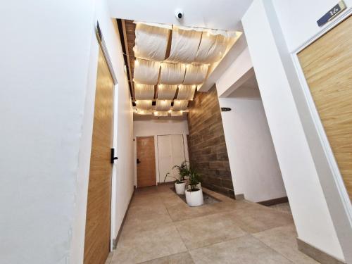 einen Flur mit weißen Wänden und einer Decke mit Licht in der Unterkunft Encantadora Confortable Hab Familiar cerca Forum Majadas y Miraflores H14 in El Rodeo