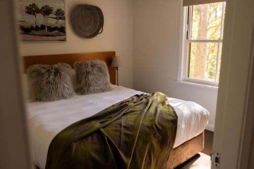 a bedroom with a bed with two pillows and a window at Villa 3br Tempranillo Villa located within Cypress Lakes Resort in Pokolbin