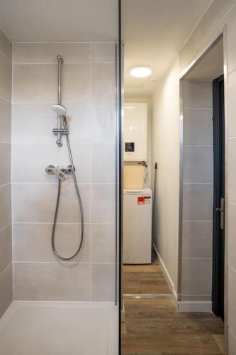 une salle de bain avec une douche avec une porte vitrée dans l'établissement LE SWEET PLACE - NETFLIX I I WIFI I CENTRE - Confort & COSY, à Anzin