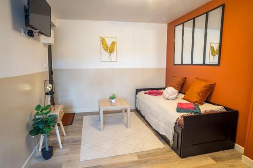 une chambre avec un lit, une table et une télévision dans l'établissement LE SWEET PLACE - NETFLIX I I WIFI I CENTRE - Confort & COSY, à Anzin