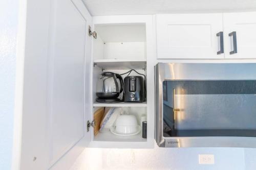 a kitchen cabinet with a microwave and a coffee maker at Trendy Studio in the Heart of Honolulu - 21F in Honolulu