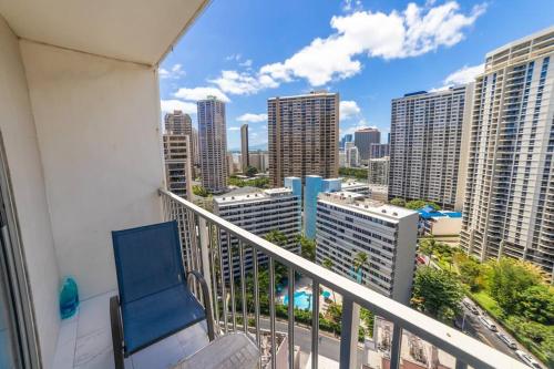 a balcony with a blue chair and a view of a city at Trendy Studio in the Heart of Honolulu - 21F in Honolulu