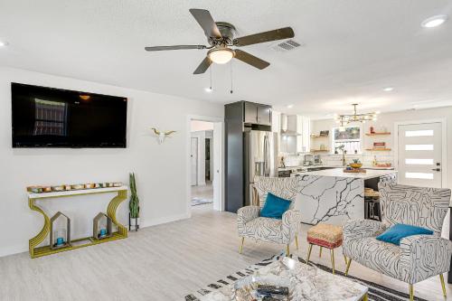 a living room with a fireplace and a ceiling fan at Less Than 1 Mi to Sea! Family and Pet-Friendly Galveston Gem in Galveston