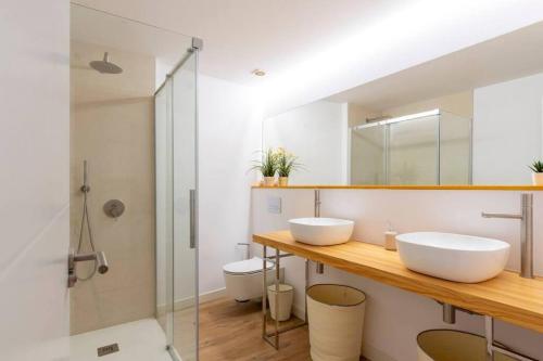 a bathroom with two sinks and a shower at Piso moderno en el centro detrás del edificio Banco Santander in Santander