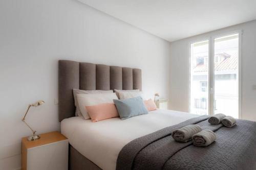 a bedroom with a large bed with pillows on it at Piso moderno en el centro detrás del edificio Banco Santander in Santander