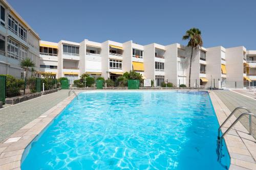 a swimming pool in front of a building at Studio de Luxe San Agustín in San Agustin