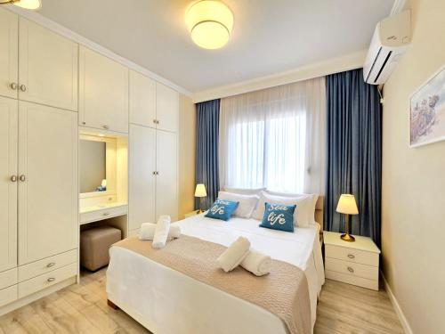 Eli's Seafront Apartment في سارنده: غرفة نوم بسرير أبيض كبير مع وسائد زرقاء