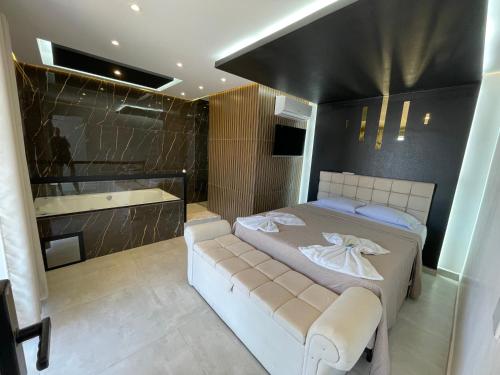 a bedroom with a bed and a shower and a tub at Suíte Gold com varanda e Hidro 302 in Santo Antônio do Descoberto