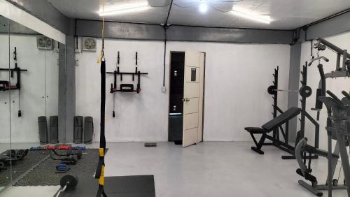 a room with a gym with weights and machines at Answer hotel in Puerto Galera