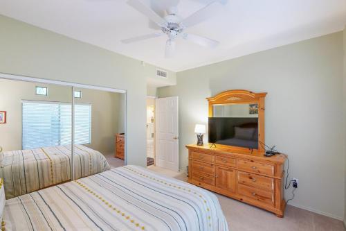 ein Schlafzimmer mit einem Bett und einem Fernseher auf einer Kommode in der Unterkunft Vistoso Resort Casita #132 in Tortolita