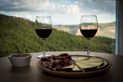 a plate of food and two glasses of wine on a table at Apartamento vacacional HM Home Yeste in Yeste