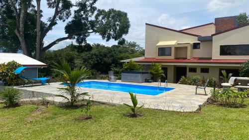 a swimming pool in front of a house at Apartamento Gratitud in Alajuela City