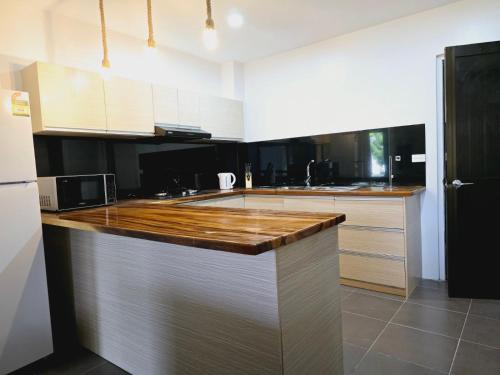 a kitchen with white cabinets and a wooden counter top at Holiday 休闲公寓 in Nakavu